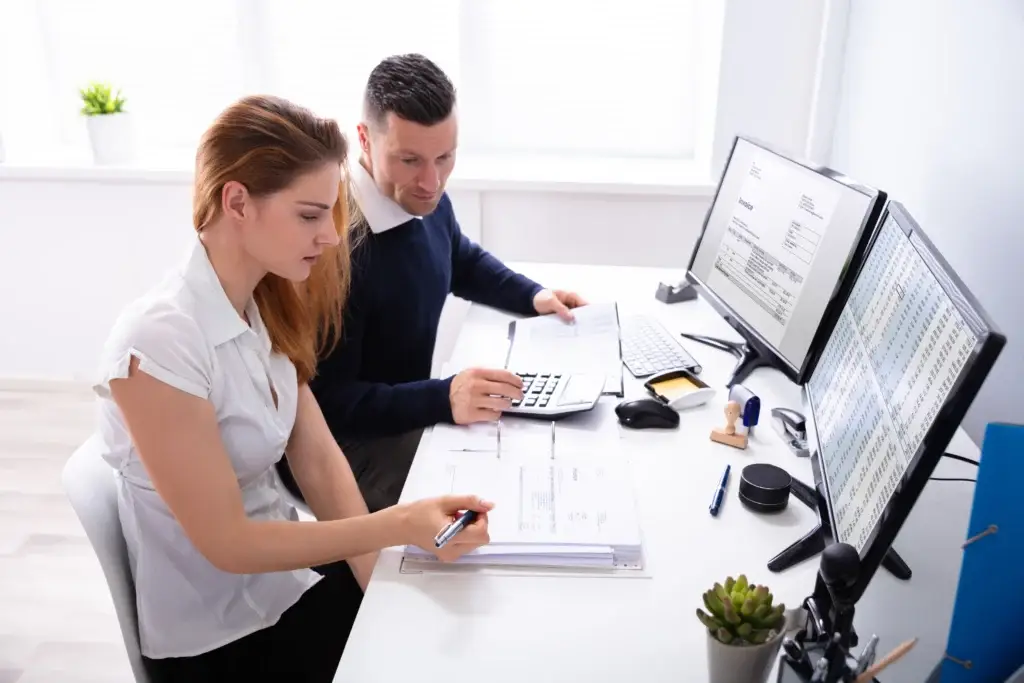 Dos empresarios realizando la factura de los trabajadores.